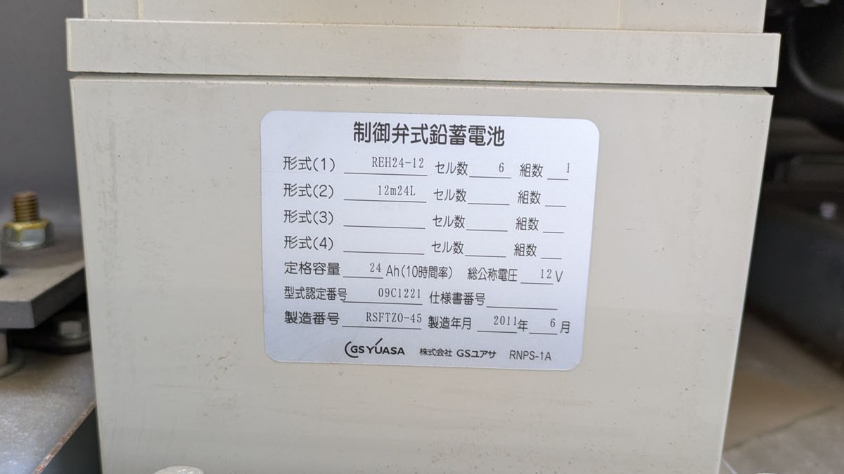 据置蓄電池の銘板（形式REH24-12・セル数6・組数1・定格容量24Ah・総公称電圧12V）