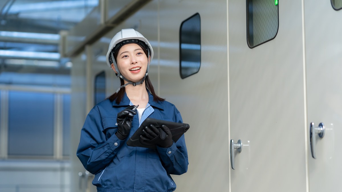 タブレットで盤の状態を記録する作業員