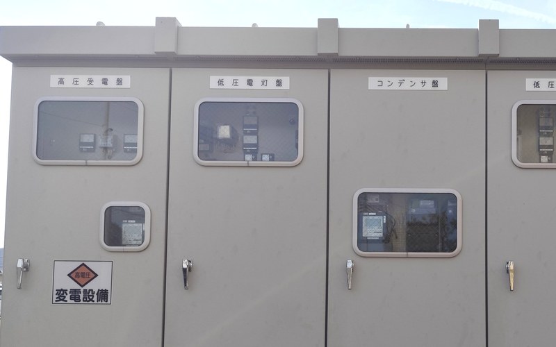 屋外に設置された受変電設備(キュービクル)の盤面(高圧受電盤・低圧電灯盤・コンデンサ盤)